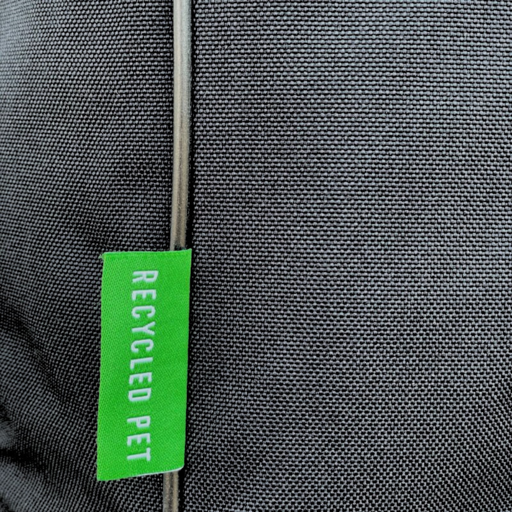 Close-up of a black bag with a bright green vertical tag reading 'RECYCLED PET' in white text.