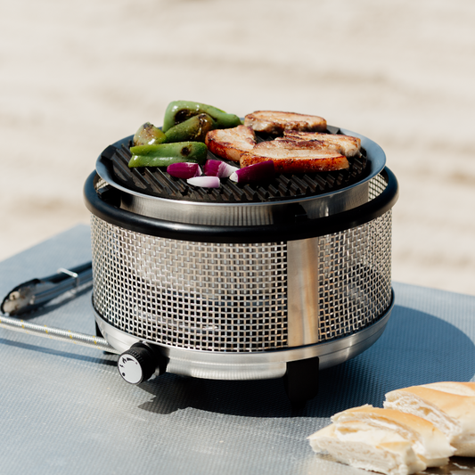 Portable grill with food on a blue surface