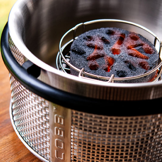 Cobb grill fire basket with a charcoal Cobble Stone burning