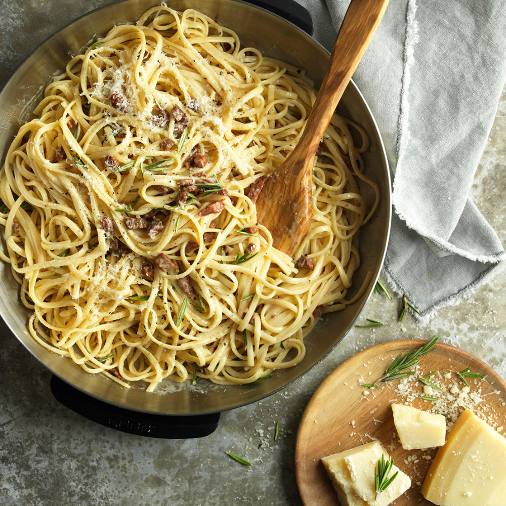 COBB Fry Dish with Pasta accompanied by Parmesan cheese on a wooden board