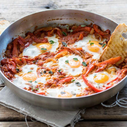 COBB Fry Dish with eggs, peppers, and bread on a wooden surface