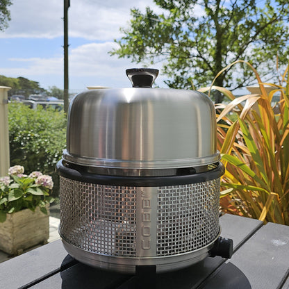 COBB Portable Gas cooker on table with green trees and plants in background