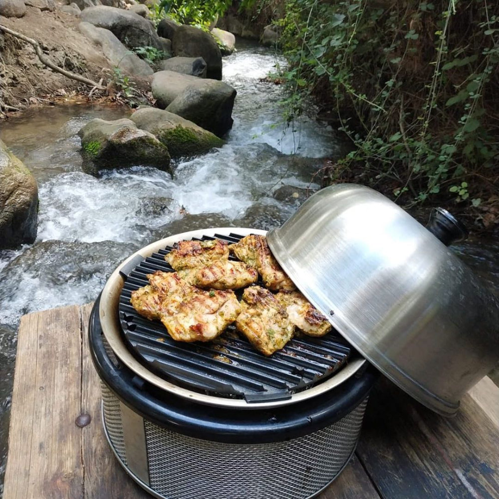 COBB Portable Outdoor Cooker grilling chicken on river