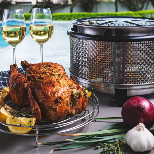 COBB portable gas cooker with roast chicken and wine in back garden