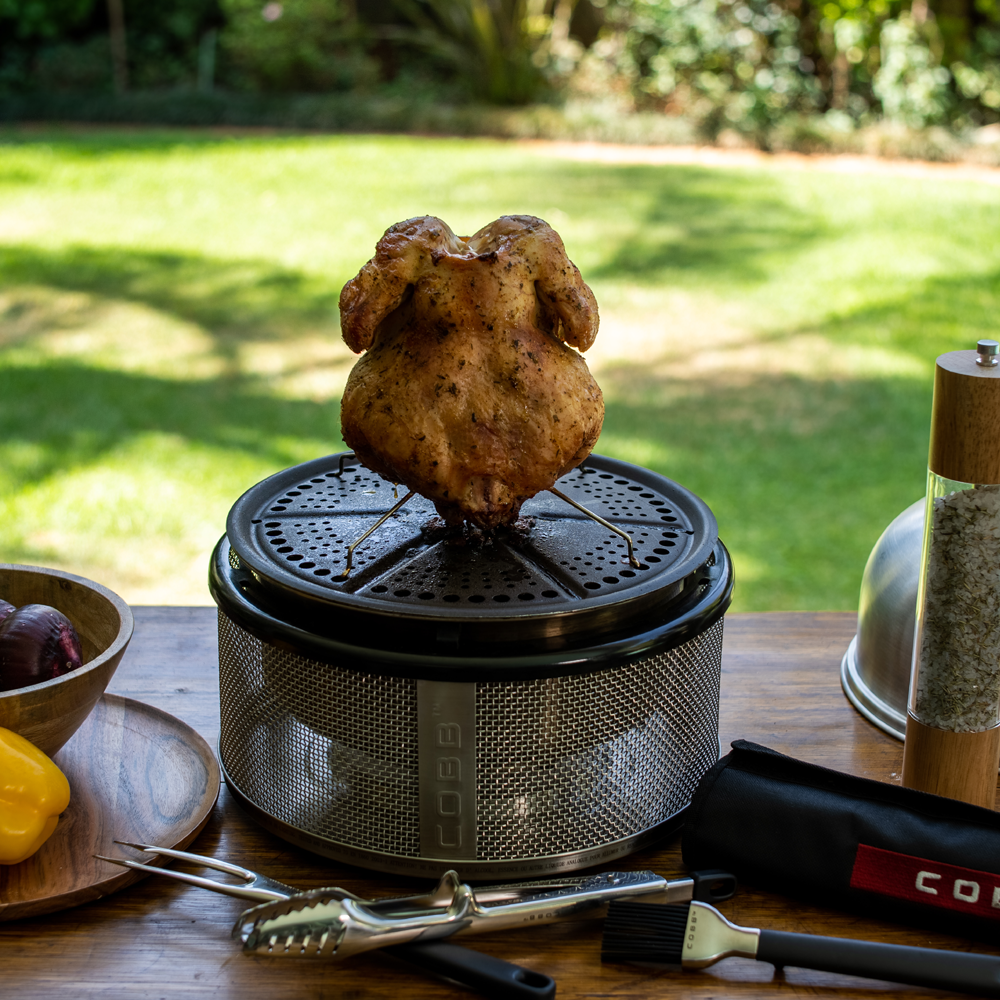Grilled chicken on a COBB portable grill with outdoor setting